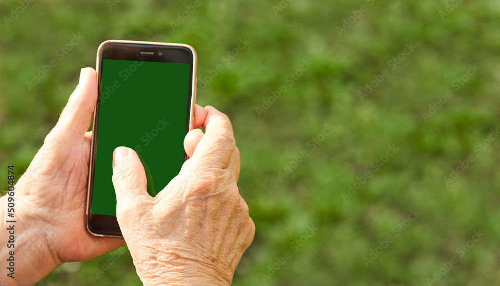 Close-up of the hands of an elderly woman using a mobile phone. Copy space image