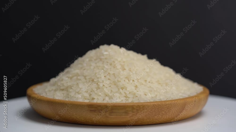 Close view raw rice grains. Looping video with rice on black background. Marketing, advertising and branding use. Close view. Studio light. Close view raw rice grains. Looping video with rice on black background. Marketing, advertising and branding use. Close view. Studio light.