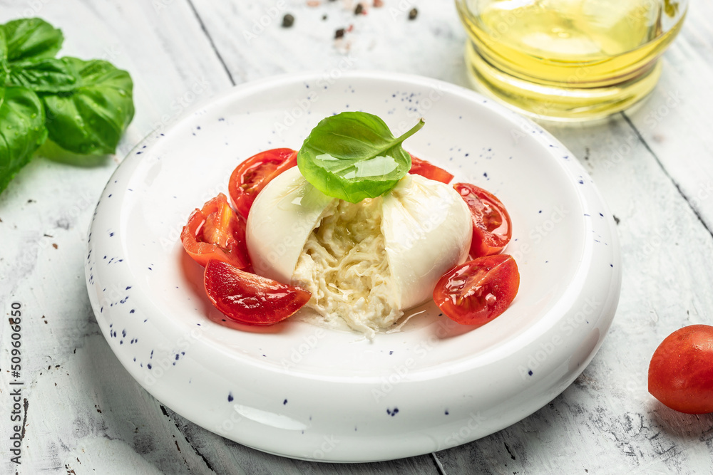 fresh soft white burrata cheese ball made from mozzarella and cream from Apulia, Italian Mediterranean cuisine, Food recipe background. Close up fresh soft white burrata cheese ball made from mozzarella and cream from Apulia, Italian Mediterranean cuisine, Food recipe background. Close up