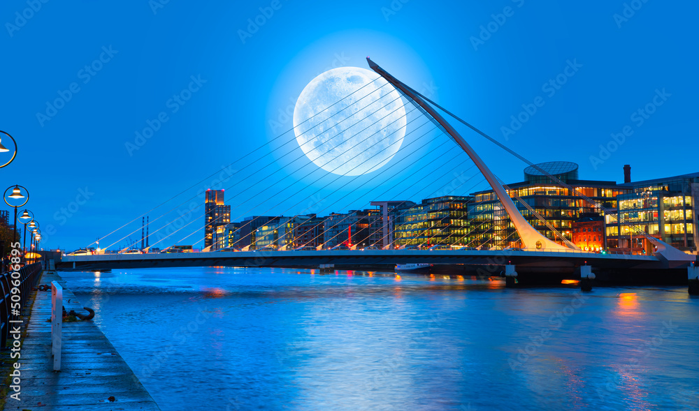 Naklejka premium Samuel Backett Bridge (Harp Bridge) at twilight blue hour with full moon - River Liffey, Dublin Ireland 