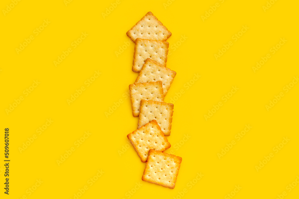 Dry cracker cookies on yellow background.