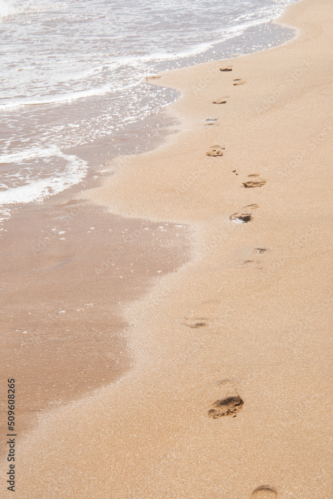 Human footprints on the beach, footprints on the yellow warm sand in summer. Human footprints on the beach, footprints on the yellow warm sand in summer.