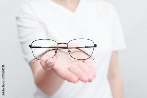 a woman holds glasses to correct eyesight. close-up
