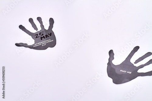 Hands silhouettes on white background. International missing childrens day. Find me message on black hand trace. photo