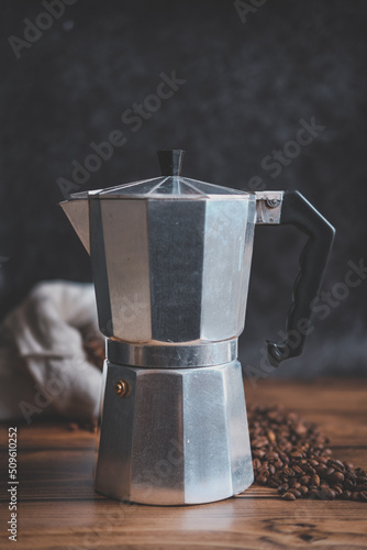 Old steel coffee pot on the wooden table and black background