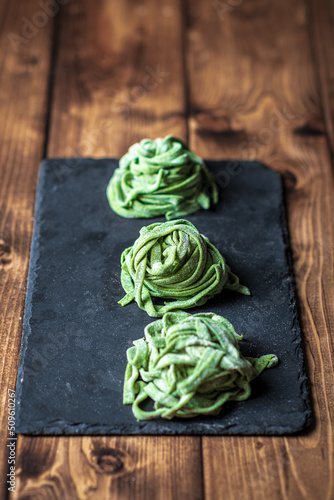 Fresh homemade spinach pasta on the black board