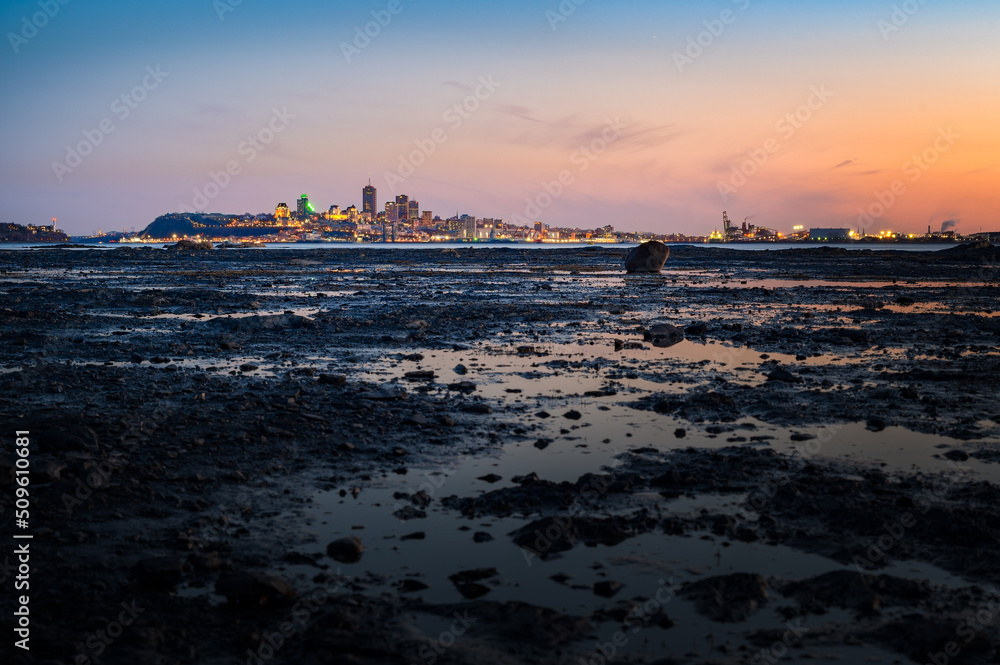 Vantage viewpoint at low tide over Quebec city's coast at blue hour viewed from Île d'Orléans, Quebec, Canada