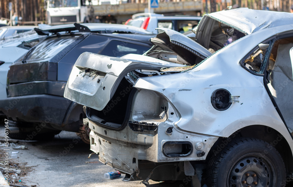Many broken cars after a traffic accident in the parking lot of a restoration service station on the street. Car body damage workshop outdoors. Sale of insurance emergency vehicles at auction.