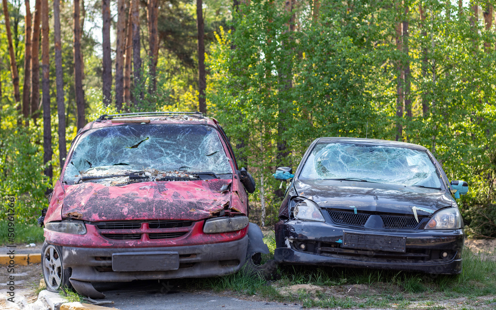 Many broken cars after a traffic accident in the parking lot of a restoration service station on the street. Car body damage workshop outdoors. Sale of insurance emergency vehicles at auction. Many broken cars after a traffic accident in the parking lot of a restoration service station on the street. Car body damage workshop outdoors. Sale of insurance emergency vehicles at auction.