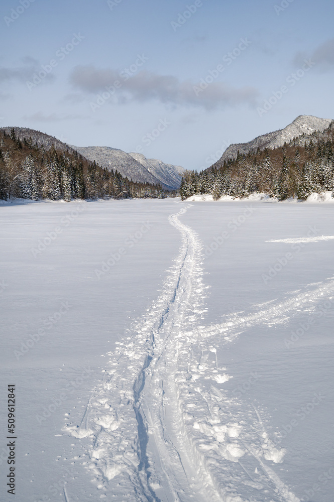 Cross-country skiing tracks that leads to the valley during a cold winter day, Jacques-Cartier river national park, QC, Canada