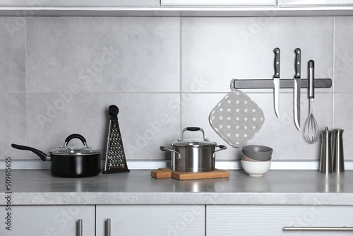 Set of cooking utensils and cookware on grey countertop