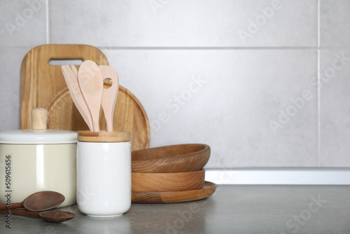 Cooking utensils and other kitchenware on grey countertop. Space for text
