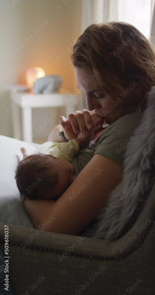 Vertical video of happy caucasian mother breastfeeding newborn baby in