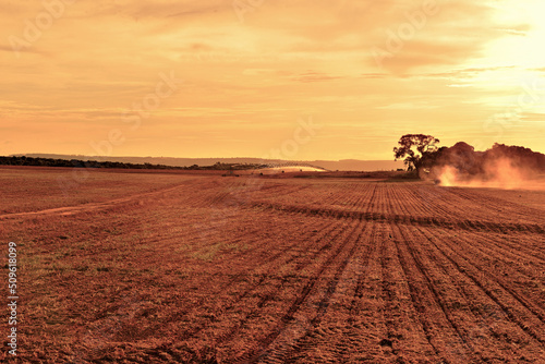 Campo arado com irrigação e por do sol photo