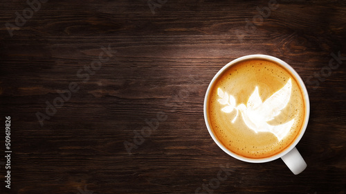 Dove bird with olive branch foam in a cup of coffee. Spiritual religion theme concept.