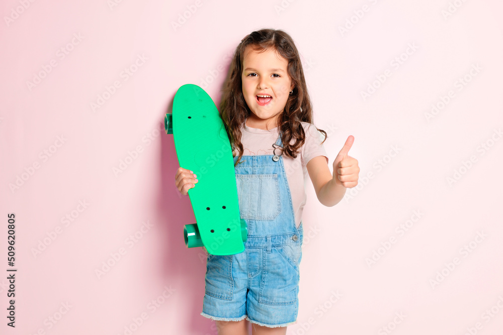 Funny little kid girl Hold skateboard on studio white background Funny little kid girl Hold skateboard on studio white background