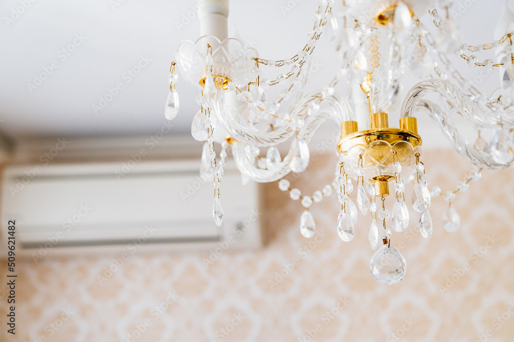 Beautiful classic crystal ceiling lamp on the ceiling of the apartment. 