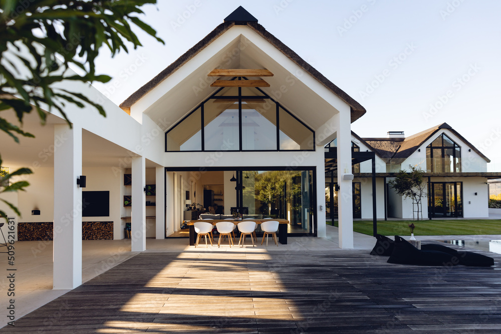 View of luxurious modern house exterior with dining space and garden - obrazy, fototapety, plakaty 