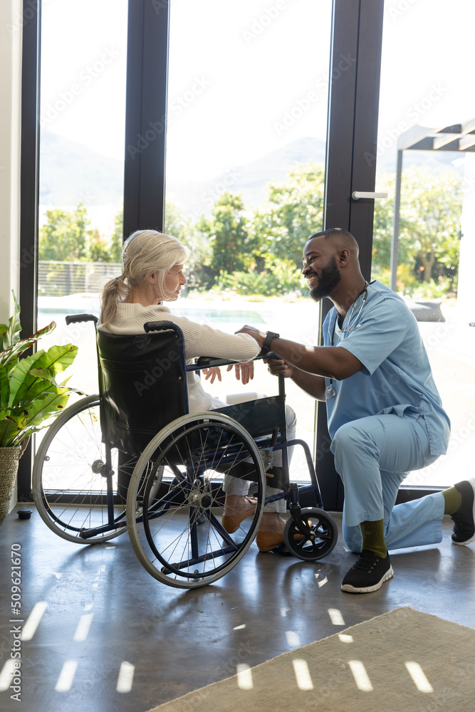 African american male health worker supporting caucasian senior woman sitting on the wheelchair African american male health worker supporting caucasian senior woman sitting on the wheelchair