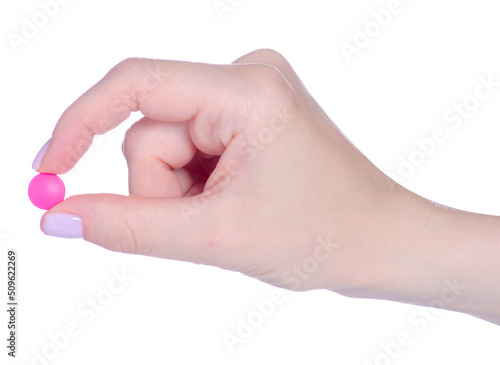 One pink pill drug in hand on white background isolation
