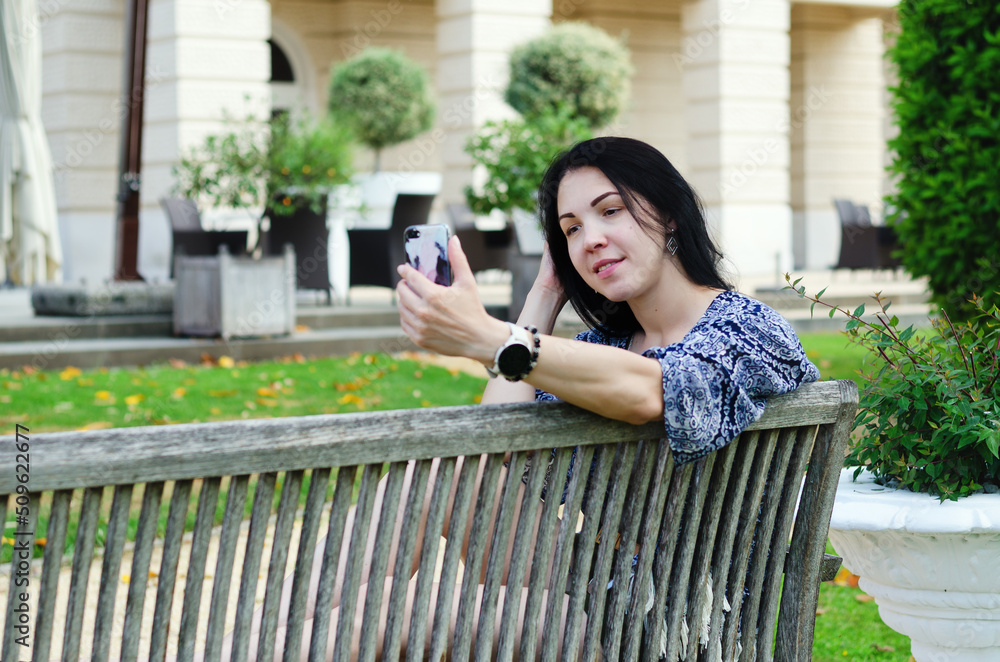 Portrait of young happy asian woman relaxing in city, park. Using phone. Selfie. technology. Social media. Video call. Summer vacation Portrait of young happy asian woman relaxing in city, park. Using phone. Selfie. technology. Social media. Video call. Summer vacation
