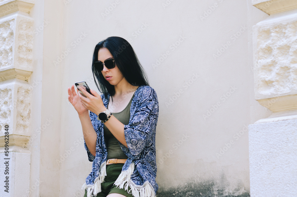 Fototapeta premium Portrait of young happy business woman relaxing in city, park at Adriatic seaside. Using phone. Selfie. technology. Social media. Video call. Summer vacation