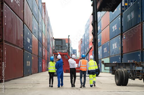 Dock manager and engineer worker discuss on quality at container shipping yard during truck lifting cargo box. Import and export product. Manufacturing transportation and global business concept