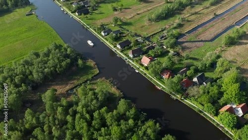 Aerial View Of A Boat Sailing On The River With Waterfront Villas At Ossenzijl In Friesland, Netherlands. photo