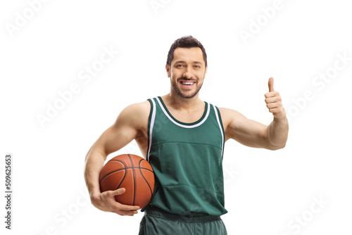 Smiling basketball player holding a ball and showing thumbs up