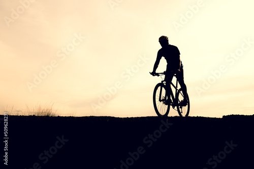 Silhouettes of mountain bikes and cyclists in the evening happily. Travel and fitness concept