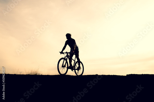 Silhouettes of mountain bikes and cyclists in the evening happily. Travel and fitness concept © STOCK PHOTO 4 U