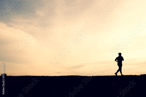 Fototapeta Naklejka Na Ścianę i Meble -  Silhouettes of men running happily in the evening. Travel and fitness concept