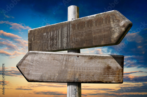 Wooden crossroad sign with two arrows photo