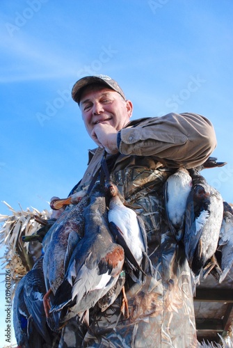 A waterfowl hunter with a strap of birds 