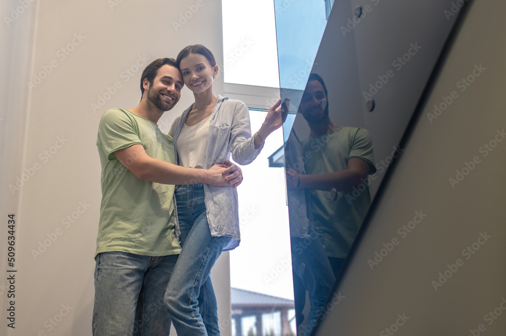Bottom view of man hugging woman smiling at camera Bottom view of man hugging woman smiling at camera