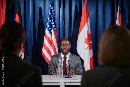 Wallpaper Mural African American representative sitting at table and taking to journalists during press conference Torontodigital.ca