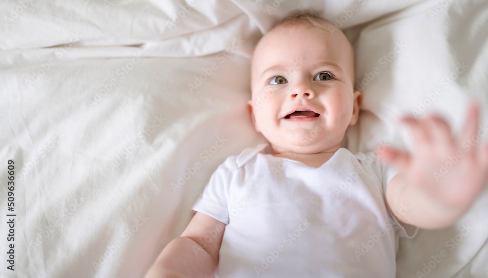 Adorable baby boy in white sunny bedroom in the morning at home Adorable baby boy in white sunny bedroom in the morning at home
