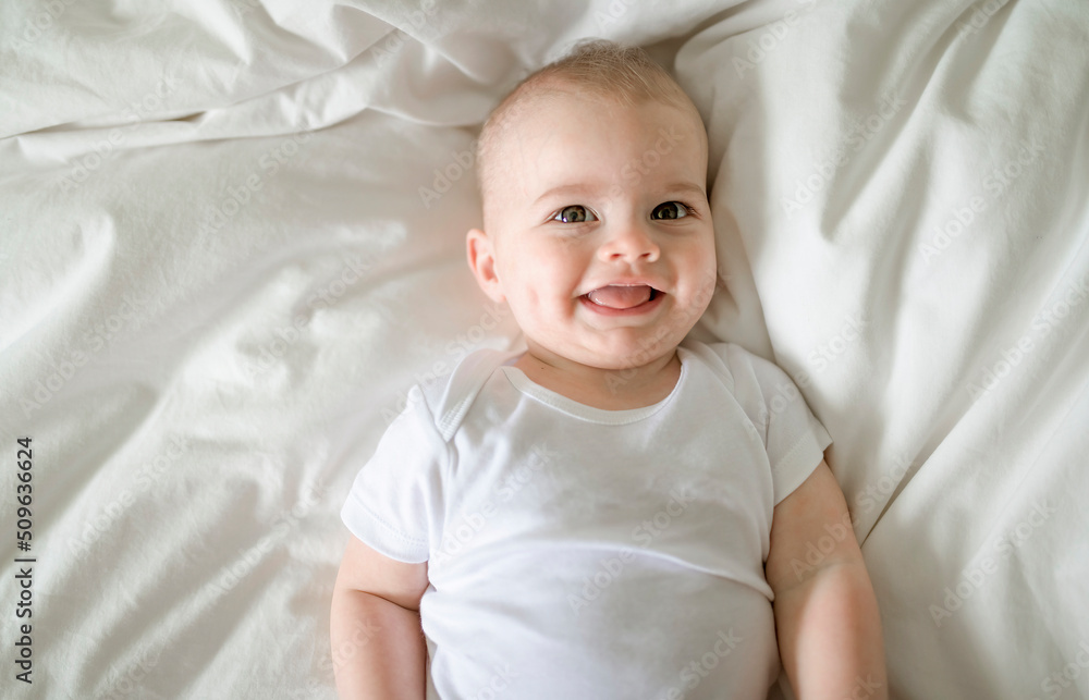 Adorable baby boy in white sunny bedroom in the morning at home Adorable baby boy in white sunny bedroom in the morning at home