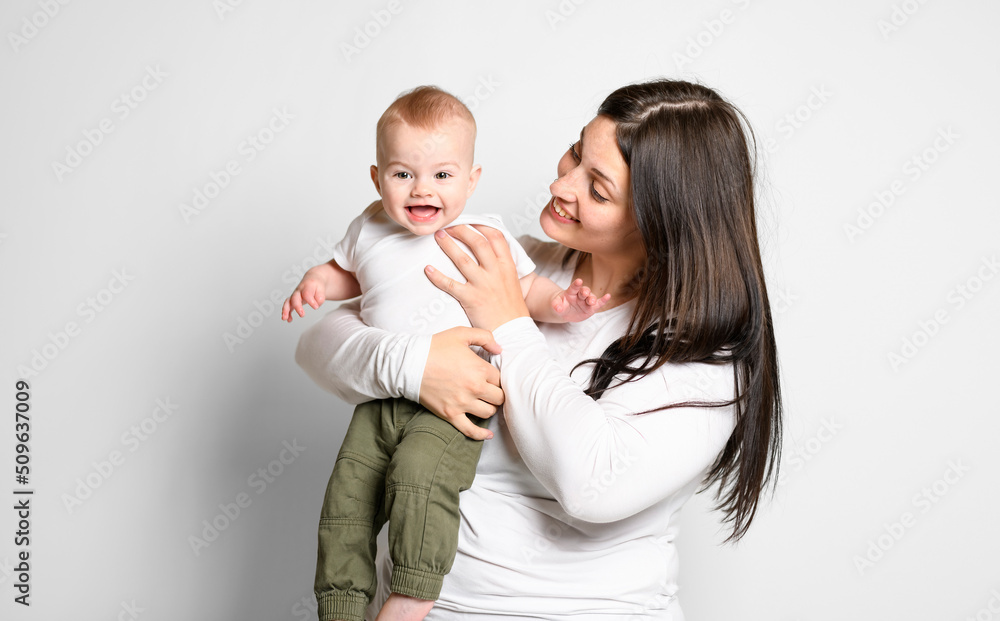 Cheerful baby boy toddler with his mother on white studio background Cheerful baby boy toddler with his mother on white studio background