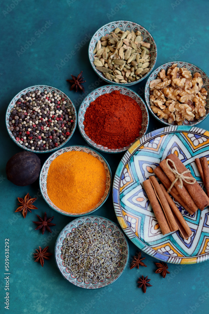 Top view arrangement with spices in bowls. Colorful picture of aromatic Indian herbs and spices on a table. Blue background with copy space. Top view arrangement with spices in bowls. Colorful picture of aromatic Indian herbs and spices on a table. Blue background with copy space.