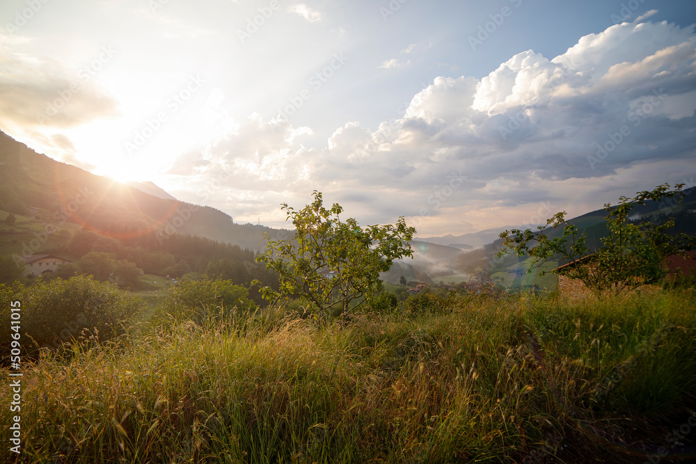 atxondo valley in bizkaia, northern spain. sunset with the orange sunlight after a rainy day. fluffy clouds in the sky. landscape photography. atxondo valley in bizkaia, northern spain. sunset with the orange sunlight after a rainy day. fluffy clouds in the sky. landscape photography.