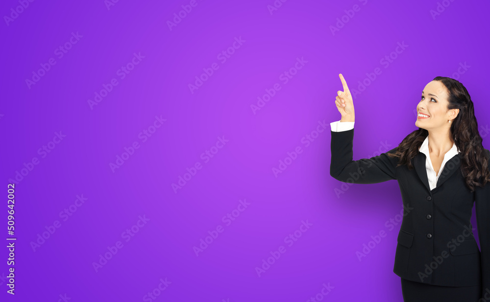 Profile portrait of smiling executive business woman in black confident suit, pointing showing up copy space. Violet purple background. Profile portrait of smiling executive business woman in black confident suit, pointing showing up copy space. Violet purple background.