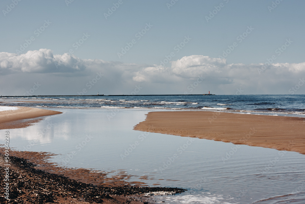 Fototapeta premium sea beach with white sand and blue water before storm. waves with white heads