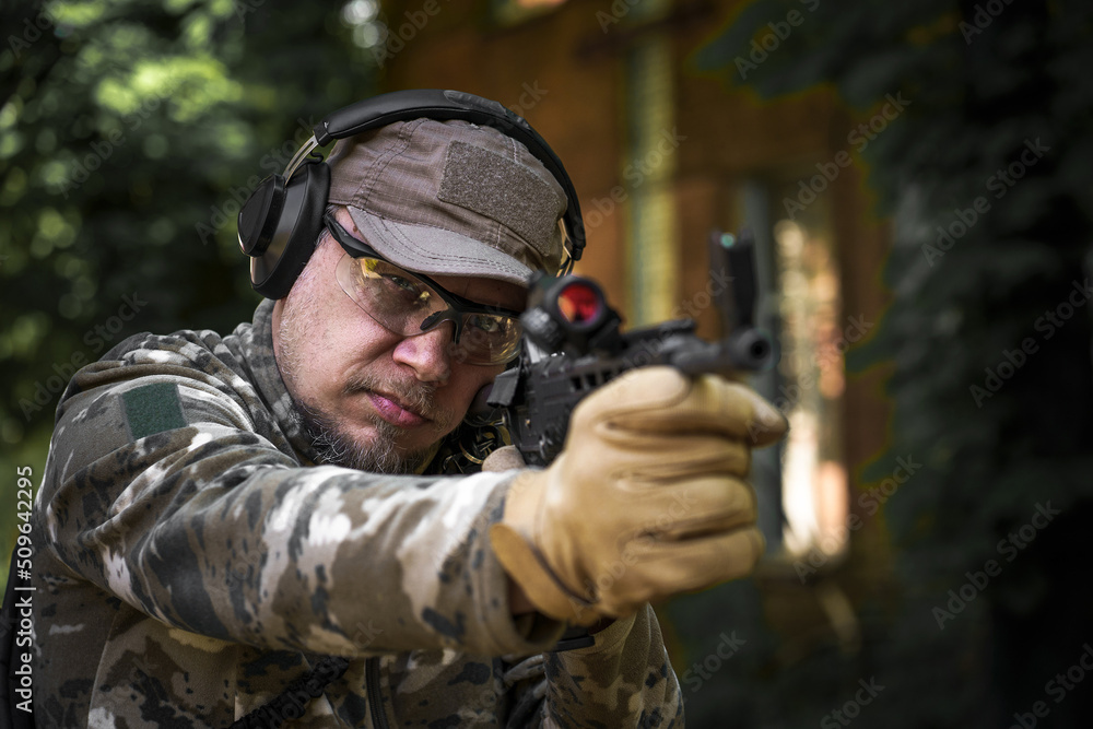 Outdoor shooting range. Police training in shooting gallery with weapon. Shotgun weapon action course. Private military contractor at tactical training course. Shooter with a gun in military uniform
