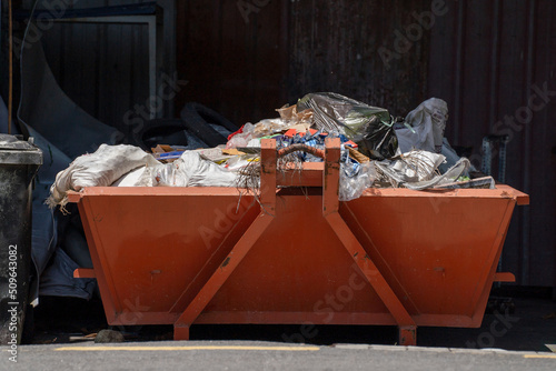 Contrustion trash in orange large steel container