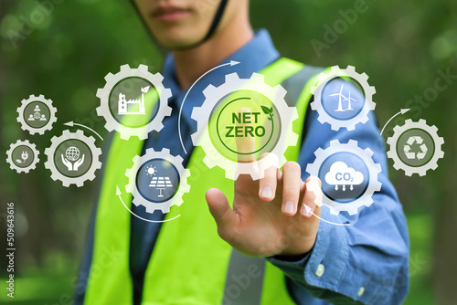 Net zero and carbon neutral concept.NET ZERO icons and symbols save the eco world and reduce pollution. environmental engineering touching green net zero icon and green icon on a green background. photo
