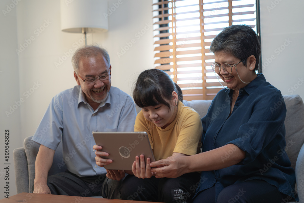Obraz premium Laughing and smiling family enjoying social media with computer tablet pad.picture focus at child in yellow shirt
