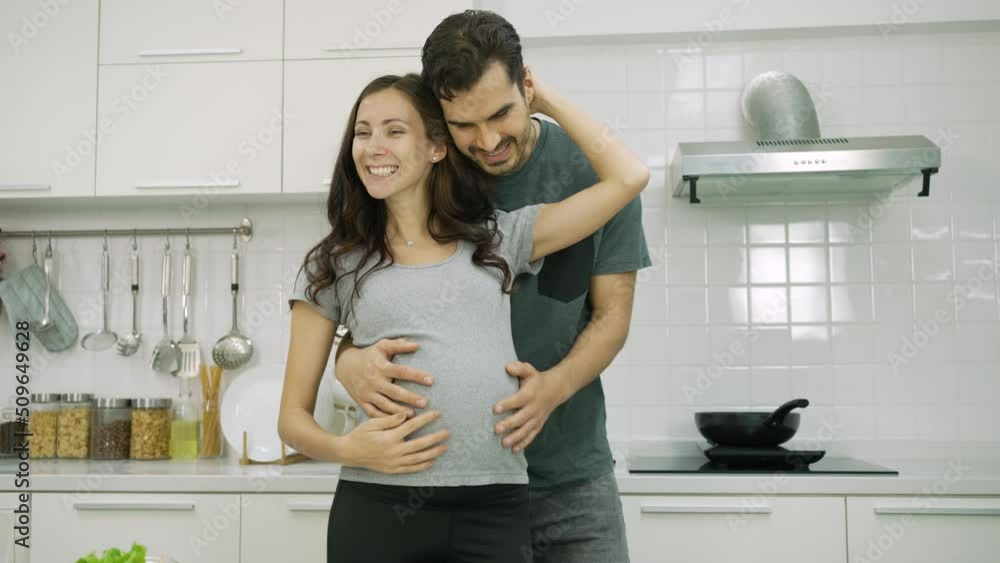 Caucasian Young Pregnant Couple Dancing Together in Kitchen. Family Relationship Caucasian Young Pregnant Couple Dancing Together in Kitchen. Family Relationship