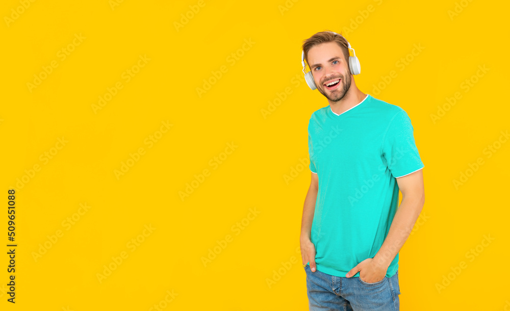 Fototapeta premium glad guy with bristle listen music on yellow background, lifestyle