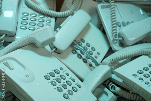 Pile of broken or unused landline telephone in cardboard boxes, Communication technology that has changed with the times, Selective focus